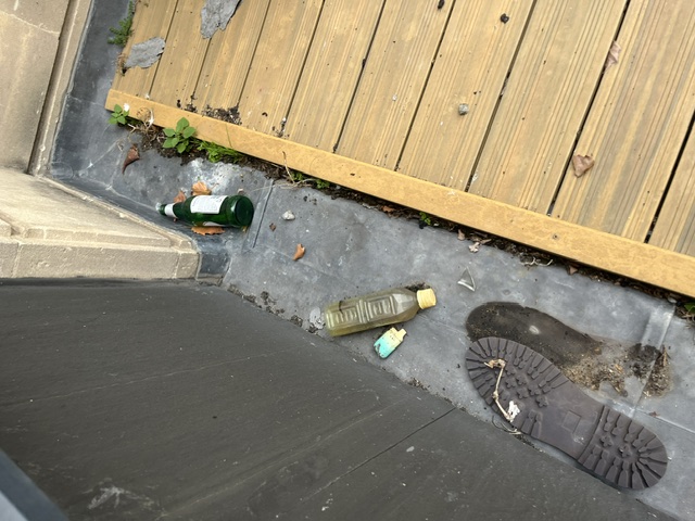 Debris and concealed edges beside exterior decking inspected during the central Bristol needle sweep
