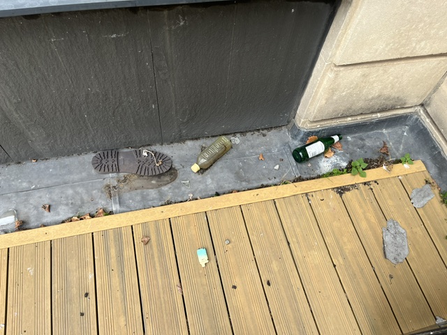 Wider view of debris and potential concealment points beside the exterior mezzanine decking in central Bristol